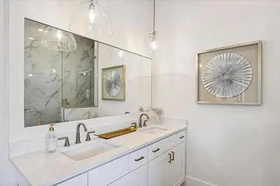 a white bathroom with a sink and a mirror at Sea Ya Soon by 30A Escapes in Rosemary Beach