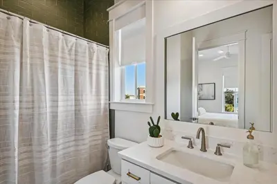 a bathroom with a sink and a toilet and a mirror at Sea Ya Soon by 30A Escapes in Rosemary Beach