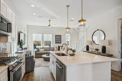 a kitchen with a sink and a living room at Sea Ya Soon by 30A Escapes in Rosemary Beach
