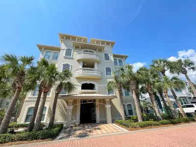 a large white building with palm trees in front of it at Poolside Paradise by 30A Escapes in Rosemary Beach