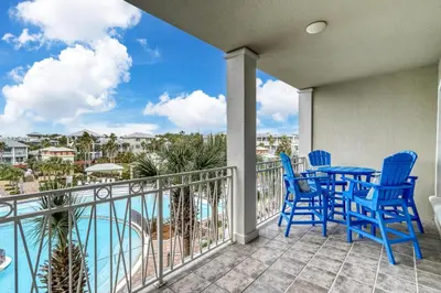 a balcony with a table and chairs and a view of the water at Poolside Paradise by 30A Escapes in Rosemary Beach