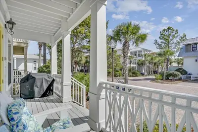 a white porch with a chair and palm trees at Endless Summer Escape by 30A Escapes in Rosemary Beach