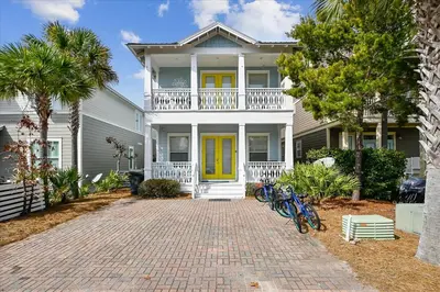 a white house with yellow doors and bikes parked in front at Endless Summer Escape by 30A Escapes in Rosemary Beach