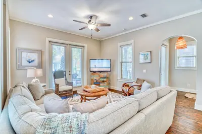 a living room with a large couch and a tv at Endless Summer Escape by 30A Escapes in Rosemary Beach