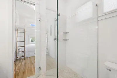 a white bathroom with a shower and a toilet at Tuscan Blue by 30A Escapes in Rosemary Beach