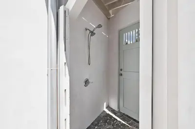 a bathroom with a shower next to a door at Tuscan Blue by 30A Escapes in Rosemary Beach