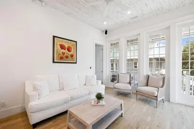 a white living room with a white couch and chairs at Tuscan Blue by 30A Escapes in Rosemary Beach