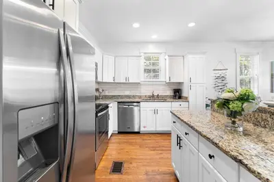 a kitchen with white cabinets and a stainless steel refrigerator at Hidden Gem #6 by 30A Escapes in Seacrest