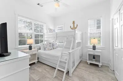 a white bedroom with a bunk bed and a desk at Hidden Gem #6 by 30A Escapes in Seacrest
