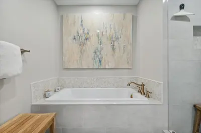 a bath tub in a bathroom with a painting on the wall at HP 45W What the Heck by 30A Escapes in Rosemary Beach