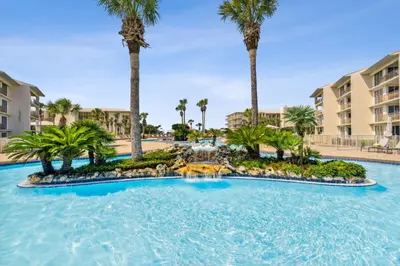 a large pool with palm trees in a resort at HP 45W What the Heck by 30A Escapes in Rosemary Beach