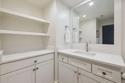 a white bathroom with a sink and a mirror at HP 21W Gulf Front Condo by 30A Escapes in Rosemary Beach