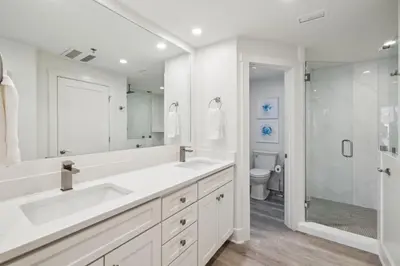 a white bathroom with two sinks and a shower at HP 21W Gulf Front Condo by 30A Escapes in Rosemary Beach