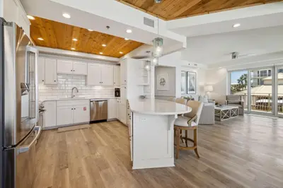 a kitchen with white cabinets and a wooden ceiling at HP 21W Gulf Front Condo by 30A Escapes in Rosemary Beach