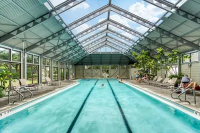 a swimming pool with a glass ceiling and people in the water at Stairway to Heaven Carriage by 30A Escapes in Rosemary Beach