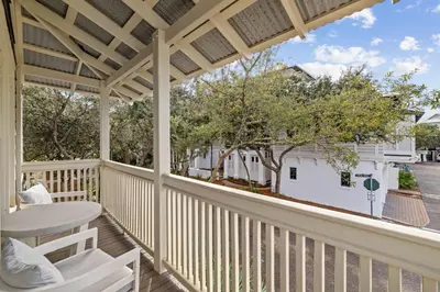 a patio with a table and chairs on a porch at Stairway to Heaven Carriage by 30A Escapes in Rosemary Beach