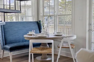 a dining room with a table and a blue couch at Stairway to Heaven Carriage by 30A Escapes in Rosemary Beach