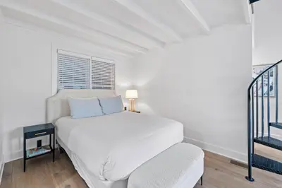 a white bedroom with a bed and a window at Stairway to Heaven Carriage by 30A Escapes in Rosemary Beach