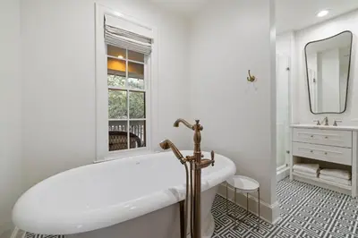 a white bathroom with a tub and a window at Stairway to Heaven Cottage by 30A Escapes in Rosemary Beach