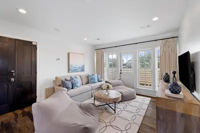 a living room with a couch and a tv at Stairway to Heaven Cottage by 30A Escapes in Rosemary Beach