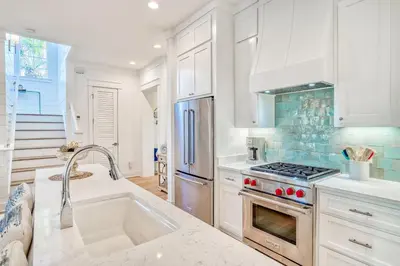 a kitchen with a sink and a stove top oven at 100 Lifeguard Loop East by 30A Escapes in Rosemary Beach