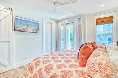 a bedroom with a bed and a couch at 100 Lifeguard Loop East by 30A Escapes in Rosemary Beach