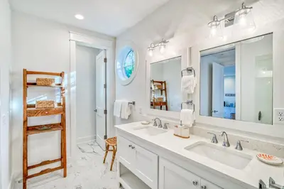 a bathroom with two sinks and a large mirror at 100 Lifeguard Loop East by 30A Escapes in Rosemary Beach