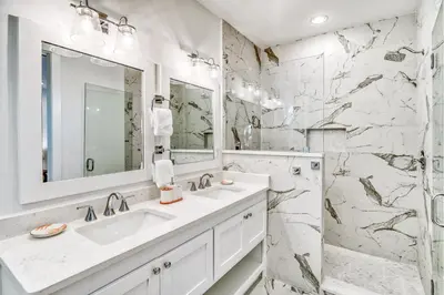 a white bathroom with a sink and a mirror at 100 Lifeguard Loop East by 30A Escapes in Rosemary Beach