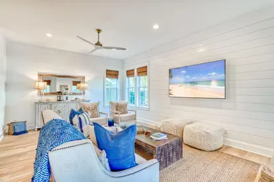 a living room with a couch and a table at 100 Lifeguard Loop East by 30A Escapes in Rosemary Beach