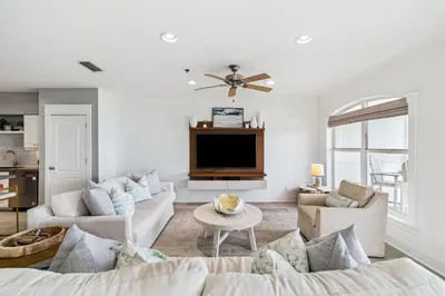 a living room with a couch and a tv at Sunset Beach 102C by 30A Escapes in Rosemary Beach