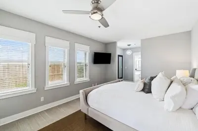 a bedroom with a white bed and windows at Sunset Beach 102C by 30A Escapes in Rosemary Beach