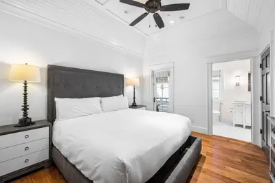 a white bedroom with a bed and a ceiling fan at 103 E Kingston by 30A Escapes in Rosemary Beach