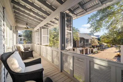 a screened in porch with chairs and windows at 103 E Kingston by 30A Escapes in Rosemary Beach