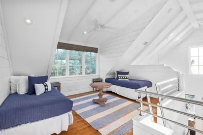 a attic room with two beds and a table at 103 E Kingston by 30A Escapes in Rosemary Beach