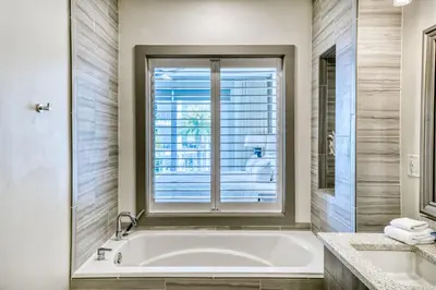 a bathroom with a bath tub and a window at The Pointe Unit 321 by 30A Escapes in Rosemary Beach