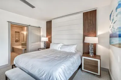 a bedroom with a large bed and a bathroom at The Pointe Unit 321 by 30A Escapes in Rosemary Beach