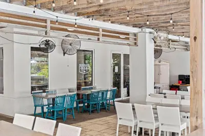 a dining room with blue chairs and tables at The Pointe Unit 321 by 30A Escapes in Rosemary Beach