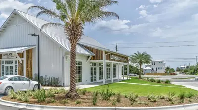 a palm tree in front of a building at Sanity By the Sea by 30A Escapes in Inlet Beach