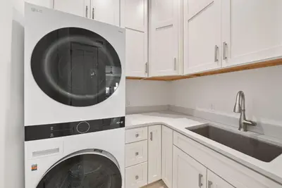 a white kitchen with a washer and dryer at The Odessa by 30A Escapes in Seagrove Beach