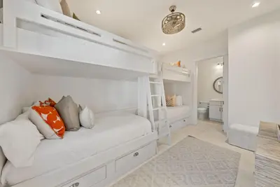 a white bedroom with a bed and a bathroom at The Odessa by 30A Escapes in Seagrove Beach