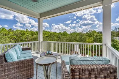 a porch with wicker chairs and a table at 134 Walton Gulfview by 30A Escapes in Seacrest