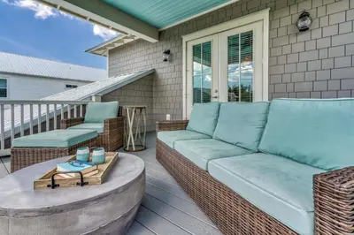 a patio with a couch and chairs on a porch at 134 Walton Gulfview by 30A Escapes in Seacrest