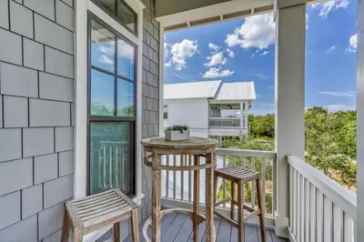 a porch with two stools and a table on a balcony at 134 Walton Gulfview by 30A Escapes in Seacrest