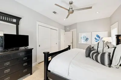 a bedroom with a bed and a flat screen tv at Casablanca by 30A Escapes in Rosemary Beach