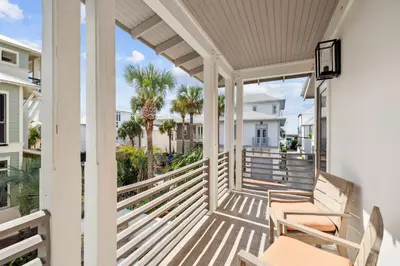a porch with two chairs and palm trees at Casablanca by 30A Escapes in Rosemary Beach