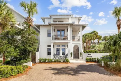 a white house with palm trees in front of it at Casablanca by 30A Escapes in Rosemary Beach