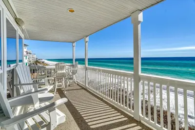 a porch with rocking chairs and the ocean at Searenity Now by 30A Escapes in Seagrove Beach
