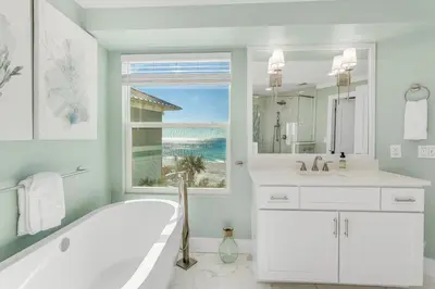 a white bathroom with a tub and a window at Searenity Now by 30A Escapes in Seagrove Beach