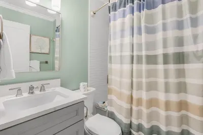 a bathroom with a sink and a shower curtain at Searenity Now by 30A Escapes in Seagrove Beach