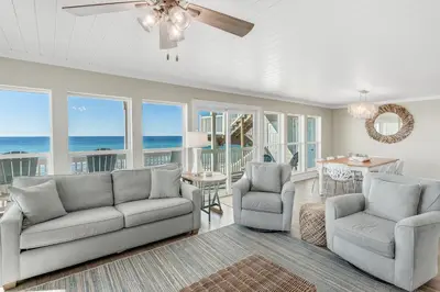 a living room with a couch and chairs and the ocean at Searenity Now by 30A Escapes in Seagrove Beach